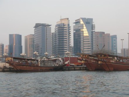 Deira skyscrapers and dhows with sunset water on Dubai Creek Deira skyscrapers and dhows with sunset water on Dubai Creek