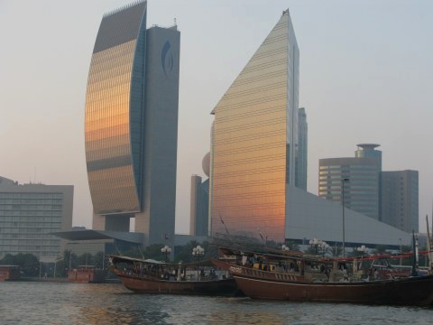 National Bank of Dubai and Chamber of Commerce Buildings with wooden ships on Dubai Creek National Bank of Dubai and Chamber of Commerce Buildings with wooden ships on Dubai Creek