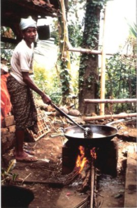 Man tending pork fat soup for Balinese village wedding