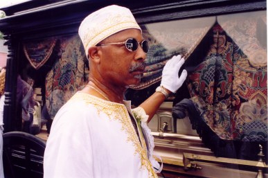 Mourner escorting horse-drawn coffin Jazz Funeral New Orleans