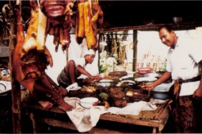Bali village wedding feast preparation with hanging pork