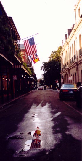 Flags reflected in puddle in the French Quarter New Orleans