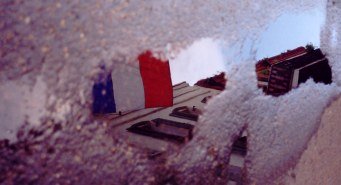 French flag reflected in puddle in the French Quarter New Orleans