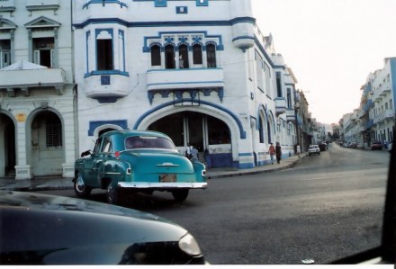 Havana-classic-cars-in-front-of-colourful-building-Habana-Centro