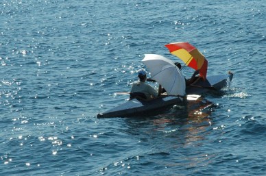 Kayak paddlers with umbrellas