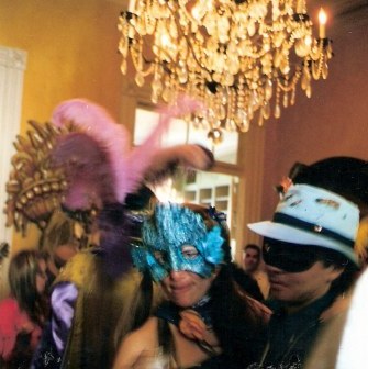 Masked revelers at French Quarter balcony party during New Orleans Mardi Gras
