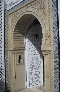 Mosaics, carvings, and black studded door in entrance in Hammamet, Tunisia