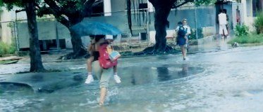 Mothers carrying children above flooded streets in Havana